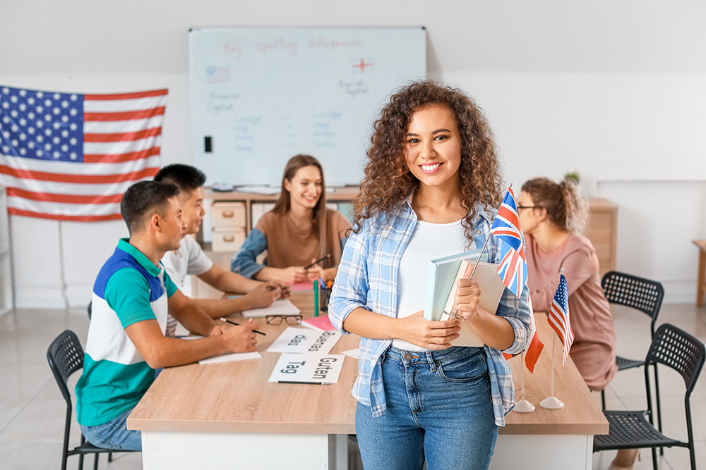 Estudante em primeiro plano, ao fundo estudantes e uma bandeira dos EUA.