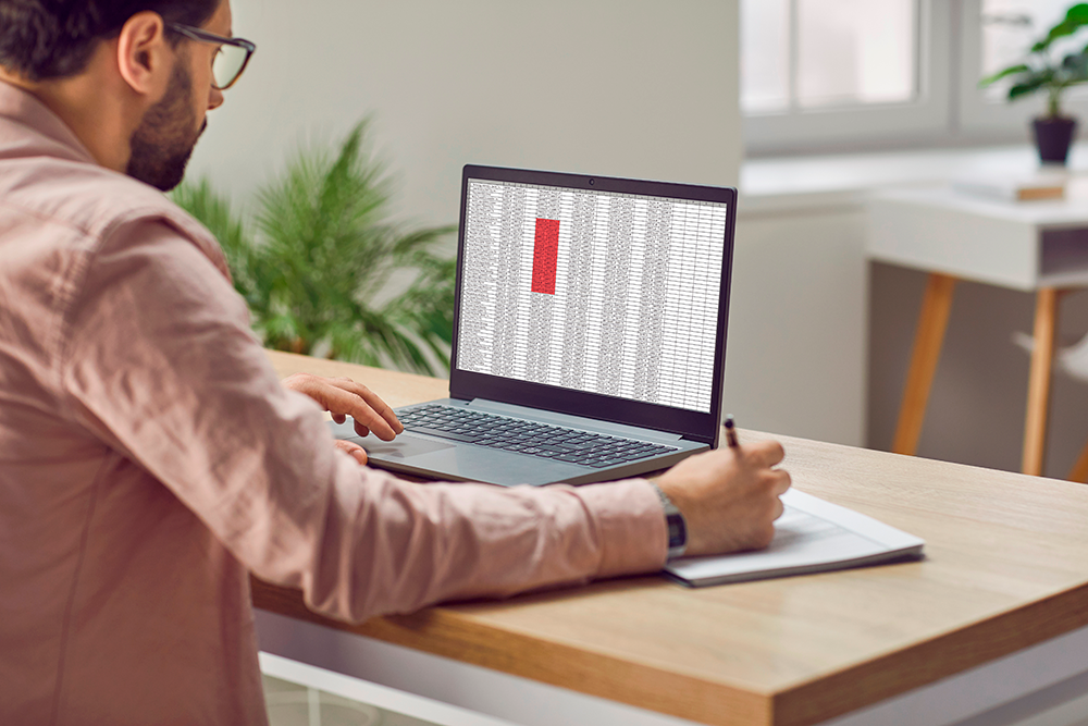 Um jovem usando o Excel no notebook, aplicando conhecimentos do nível básico ao avançado. É o retrato de quem busca se destacar com habilidades em Excel para o primeiro estágio ou área administrativa. 