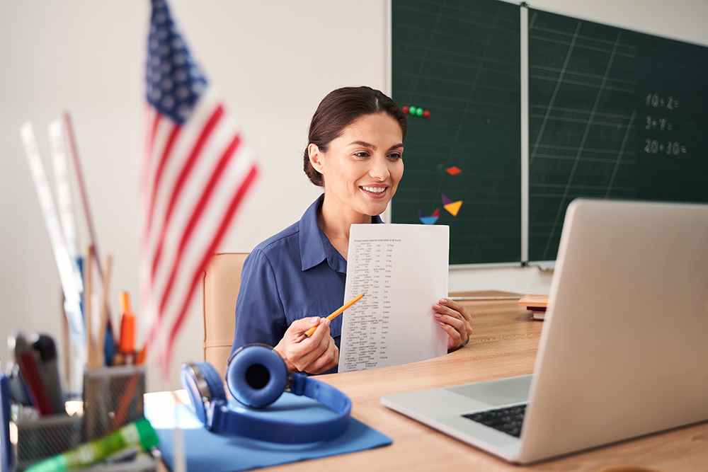 professora sorrindo e olhando para o computador