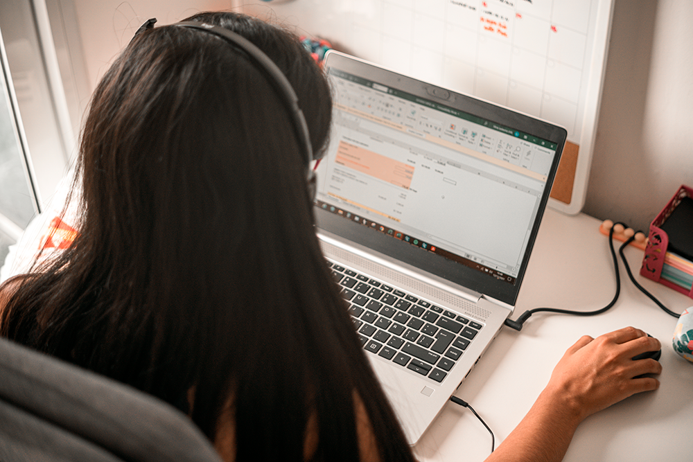 Jovem utiliza o computador para trabalhar em uma das planilhas prontas no Excel, mostrando como o domínio dessa ferramenta pode facilitar a organização e a produtividade no dia a dia profissional. 
